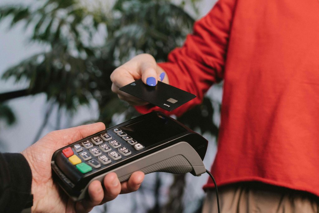 Contactless card payment using a credit card and POS terminal in Iceland Person using contactless payment with a credit card on a card reader terminal