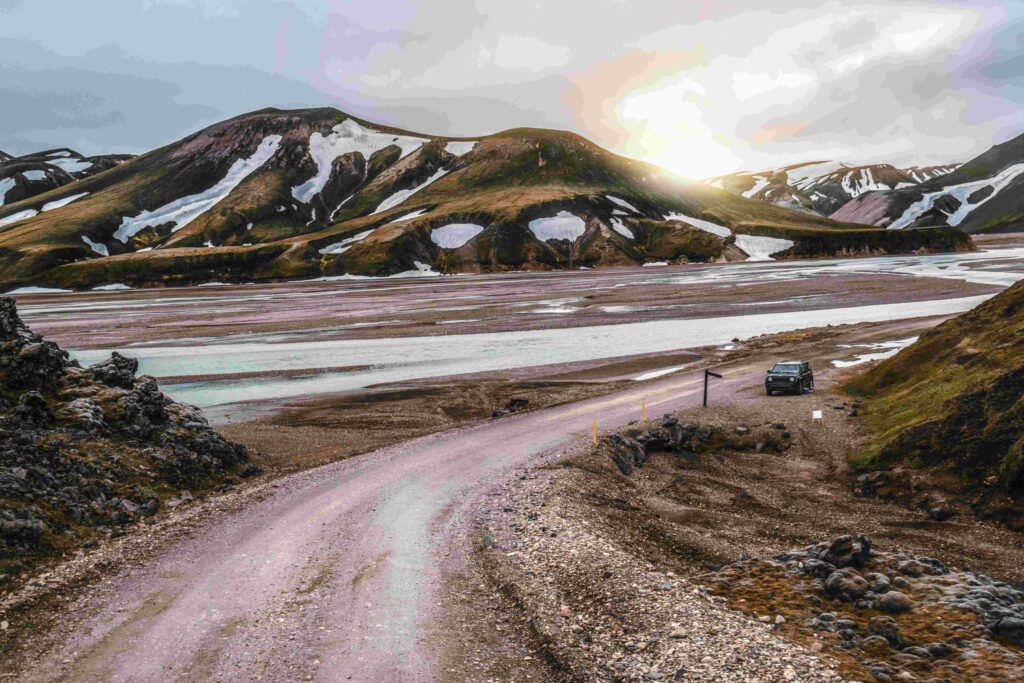 4x4 rental car on gravel road near Landmannalaugar mountains in Iceland highlands — Thrifty Car Rental Iceland self-drive adventure.